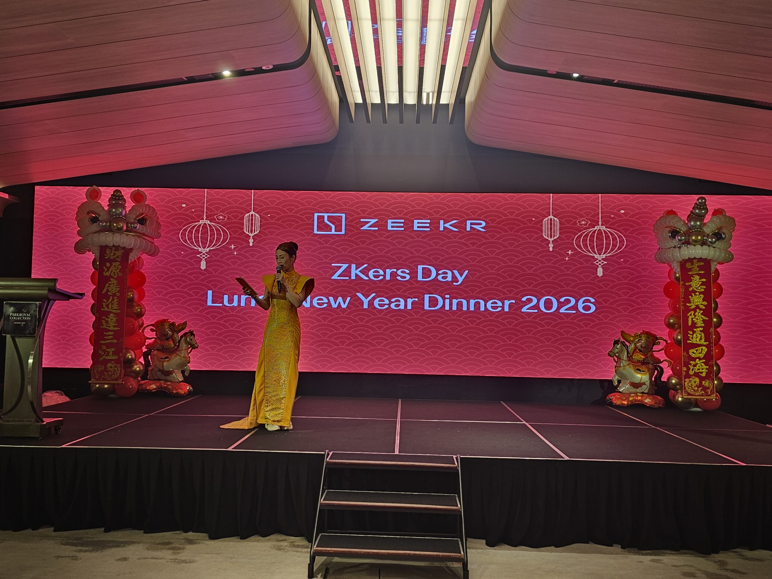 Balloon lion head Singapore CNY stage decoration with emcee in yellow cheongsam