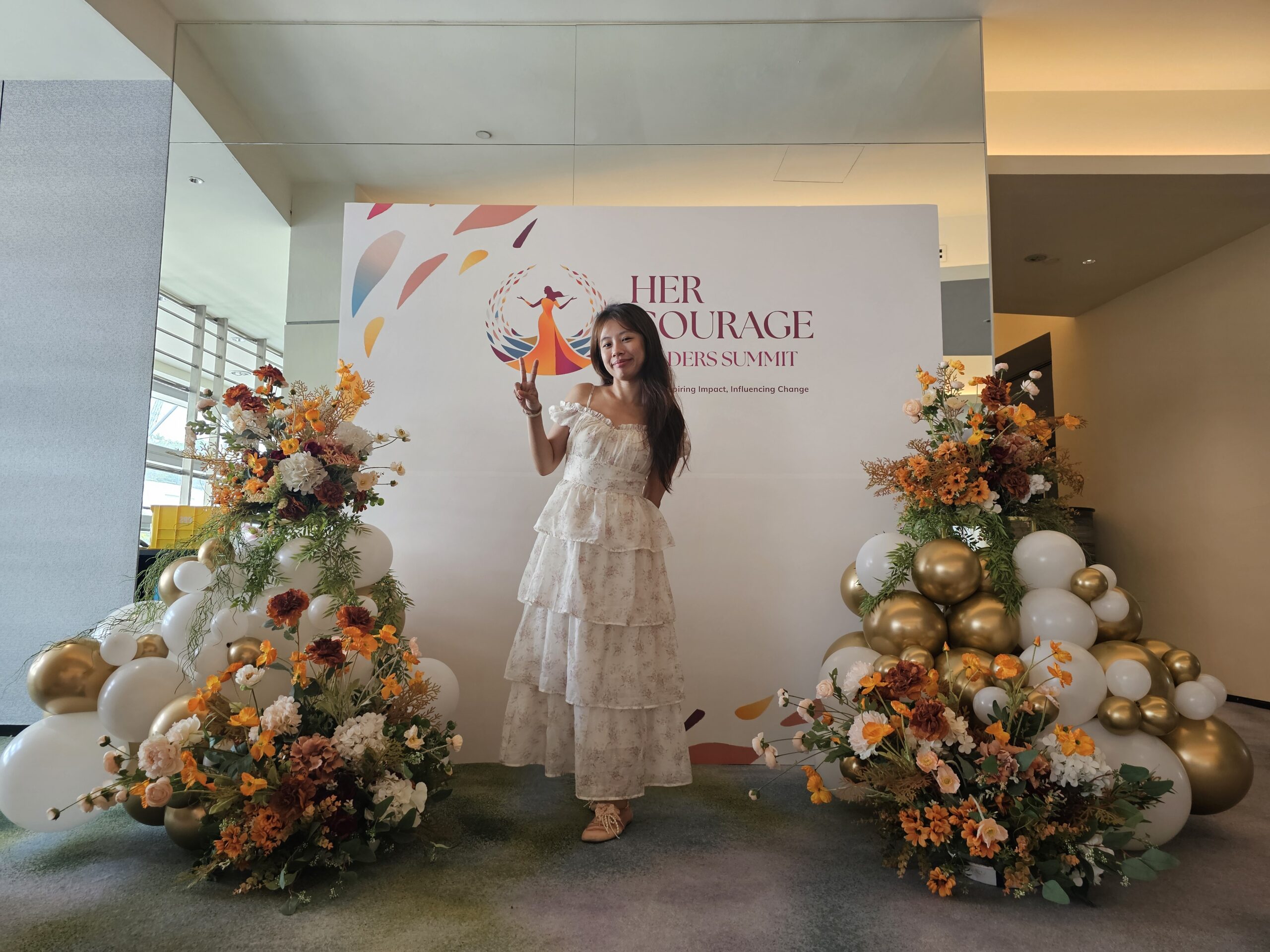 Guest posing at event balloon decoration Singapore Her Courage Summit backdrop