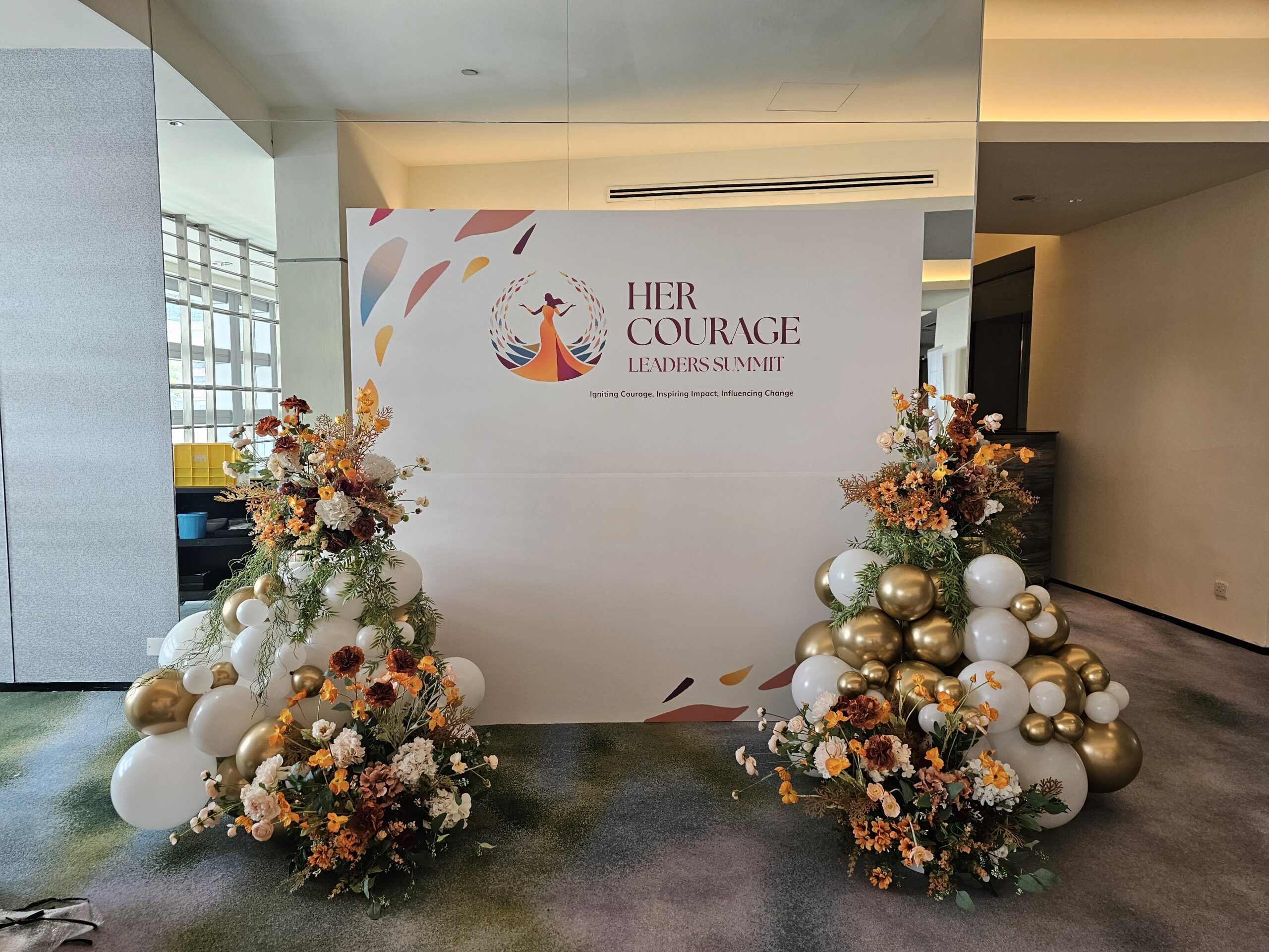 Organic balloon garland Singapore with autumn florals flanking summit photo wall